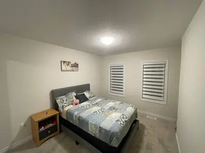 a small bedroom with a bed and a night stand at Cozy 3-Bedrooms T-Home #Niagara in Thorold