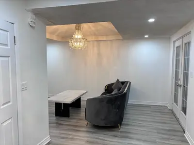 a living room with a black chair and a wooden table at Entire bungalow, full privacy, free parking in Oshawa