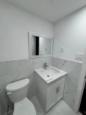 a white bathroom with a toilet and a mirror at Entire bungalow, full privacy, free parking in Oshawa