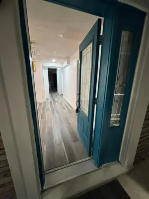 an empty hallway with a blue door and a mirror at Entire bungalow, full privacy, free parking in Oshawa