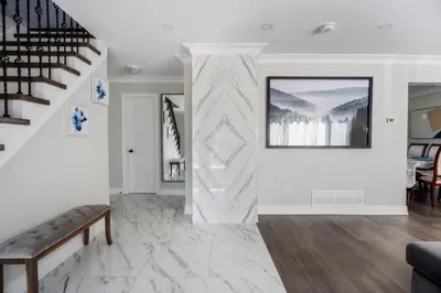 a living room with white walls and a staircase at Chic and Cozy 5 Bedroom House in Brampton