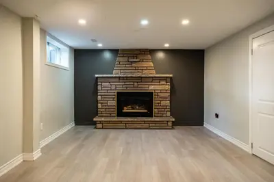 a living room with a brick fireplace in a house at Chic and Cozy 5 Bedroom House in Brampton