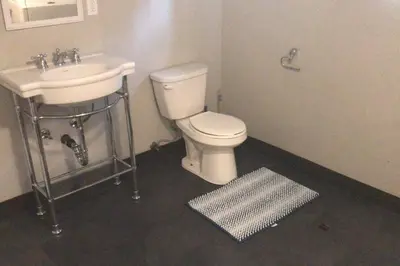 a bathroom with a white toilet and a sink at Affordable 2BR Family Friendly Basement Apt in Bowmanville