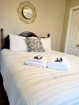 a bedroom with a bed with towels on it at Nancy by the Bay Wasaga Beach in Wasaga Beach