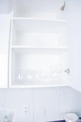 a white cabinet with dishes on top of it at Cozy Haven 2 bedroom Basement apartment with Treated water in London