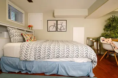 a bedroom with a bed and a chair at Charming Basement Suite with Private Entrance Near Subway, Koreatown & UofT in Toronto