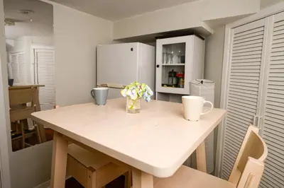 a kitchen with a table with flowers and a refrigerator at Charming Basement Suite with Private Entrance Near Subway, Koreatown & UofT in Toronto