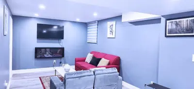 a living room with a red couch and a tv at Garden Avenue Homes Free Parking in Brantford