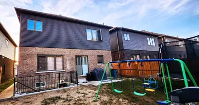 a playground in a yard in front of a house at Garden Avenue Homes Free Parking in Brantford