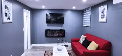 a living room with a red couch and a tv at Garden Avenue Homes Free Parking in Brantford
