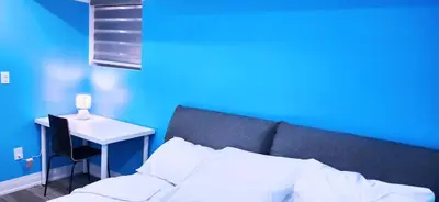 a blue room with a bed and a small table at Garden Avenue Homes Free Parking in Brantford