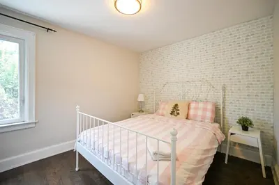 a bedroom with a white bed and a brick wall at Bright and Quiet Bedroom near Subway, Koreatown and UofT in Toronto