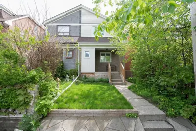 a small house with a yard with a grass yard at Bright and Quiet Bedroom near Subway, Koreatown and UofT in Toronto