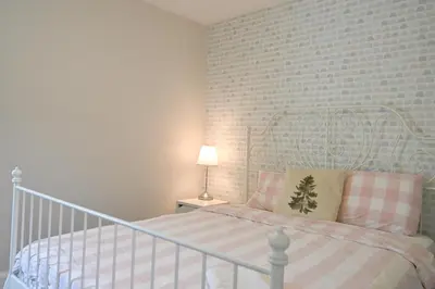 a bedroom with a bed with a white crib at Bright and Quiet Bedroom near Subway, Koreatown and UofT in Toronto