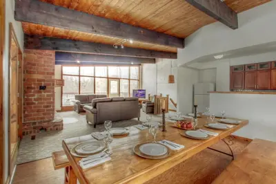 a dining room with a table and a living room at 6 bdrm Cottage at Blue Mountain, Private Beach Access, Hot Tub, Sauna, BBQ, Petfriendly in Blue Mountains