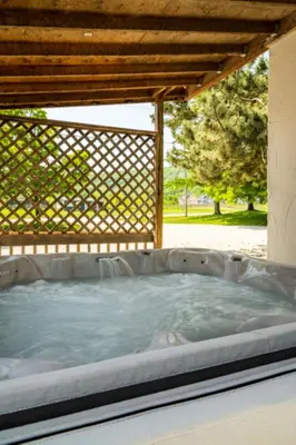 a hot tub in a backyard with a pergola at 6 bdrm Cottage at Blue Mountain, Private Beach Access, Hot Tub, Sauna, BBQ, Petfriendly in Blue Mountains