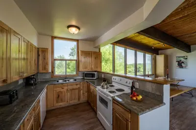 a large kitchen with wooden cabinets and white appliances at 6 bdrm Cottage at Blue Mountain, Private Beach Access, Hot Tub, Sauna, BBQ, Petfriendly in Blue Mountains