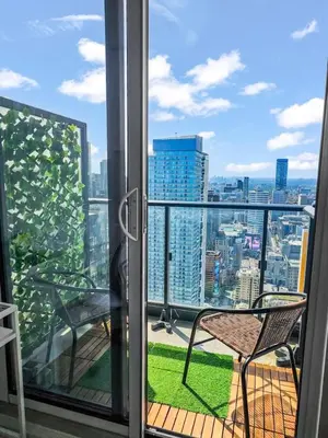 a balcony with a chair and a view of the city at The Cityscape by Instant Suites - PentHouse Unit in Toronto