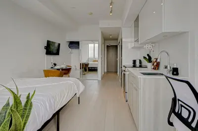 a white kitchen with a sink and a counter at The Cityscape by Instant Suites - PentHouse Unit in Toronto