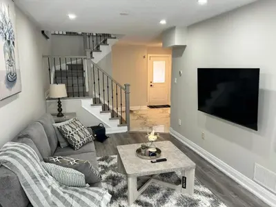 a living room with a couch and a tv at Treasure Haven Near Tourism Barrie in Barrie