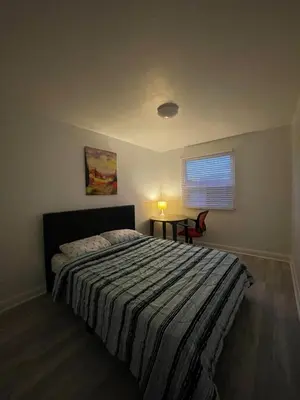 a bedroom with a bed and a table and a window at Toronto Midtown Room with Queen Bed in Toronto