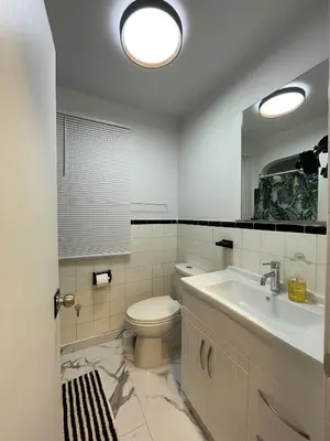 a bathroom with a toilet and a sink and a mirror at Toronto Midtown Room with Queen Bed in Toronto