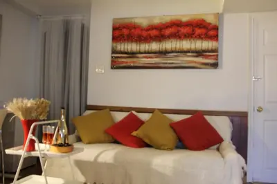 a living room with a white couch with colorful pillows at Serene Don River Nature gateway- 2BR suite, Private Patio, Free Parking in Toronto