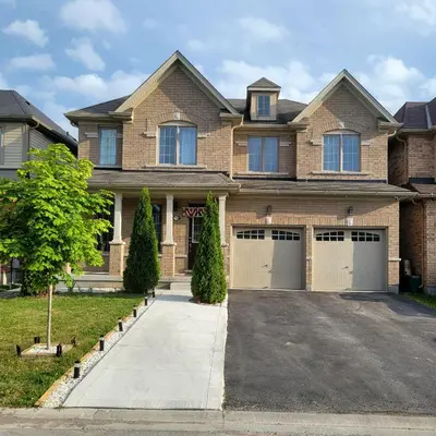 a large brick house with two garage doors at Beautiful Family Suites - Master Bedroom in Niagara Falls