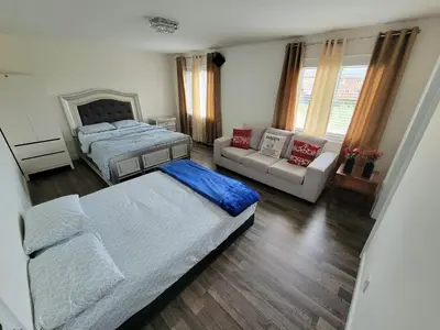 a bedroom with two beds and a couch at Beautiful Family Suites - Master Bedroom in Niagara Falls