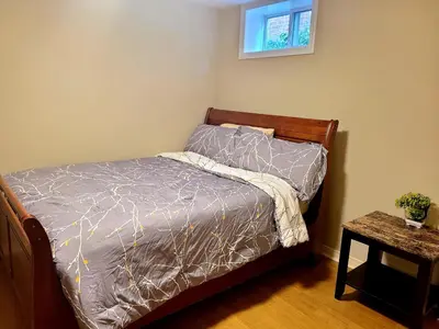 a bedroom with a bed with a bedspread and a table at Charm Heaven - Workspace, Wi-Fi, 3-Beds and Private Entrance in Pickering