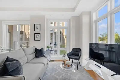 a living room with a couch and a tv at Designer Yorkdale 2BR Townhouse, Private Patio, Parking in Toronto