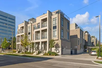 a large building on a city street with a street at Designer Yorkdale 2BR Townhouse, Private Patio, Parking in Toronto