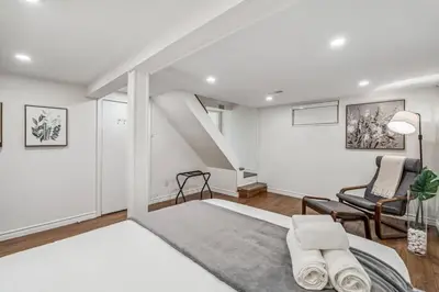 a white room with a bed and a chair at Heritage 3BR Etobicoke Gem, Sherway Gardens, BBQ in Toronto