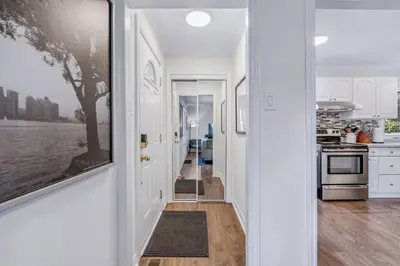 a kitchen with white walls and a hallway with white cabinets at Heritage 3BR Etobicoke Gem, Sherway Gardens, BBQ in Toronto