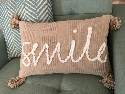 a pink crochet pillow sitting on a green chair at The Lakeview Loft in Port Colborne