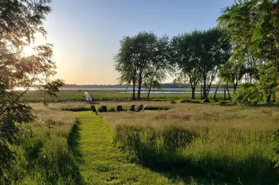 a path through a field with trees and a giraffe at Gate House Comfort plus own lake access, dock, 4 mins to beach in West Lake