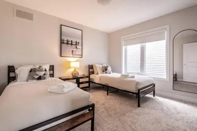 a bedroom with two beds and a window at Spotless 4 bed and 3 bath with Wi-Fi and 1hr to Niagara in Hamilton