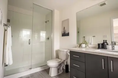 a bathroom with a shower and a toilet and a sink at Spotless 4 bed and 3 bath with Wi-Fi and 1hr to Niagara in Hamilton