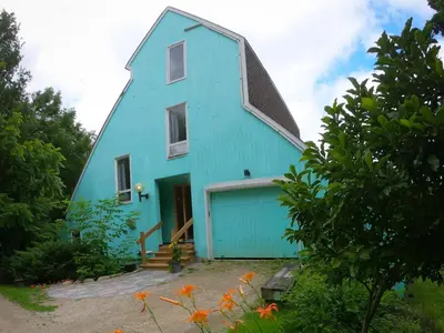 a blue barn with a blue garage at Riverside Retreat with Sauna & Hot Tub in Elora in Elora
