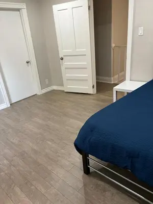 a bedroom with a blue bed and a wooden floor at H men's dormitory in Hamilton