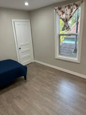 a bedroom with a bed and a window with a curtain at H men's dormitory in Hamilton