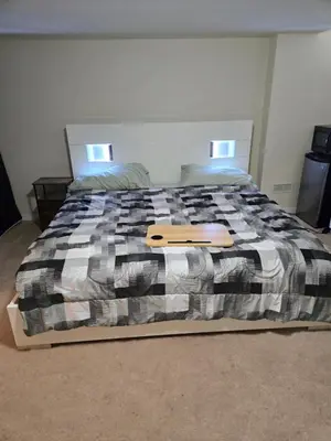 a bedroom with a bed with a wooden tray on it at Mimis lodge in Brampton
