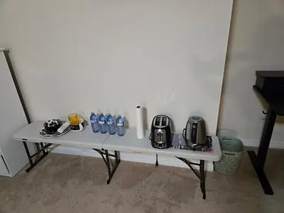 a white table with bottles of water on it at Mimis lodge in Brampton