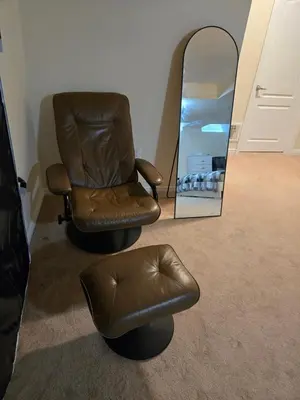 a brown chair and a mirror in a room at Mimis lodge in Brampton