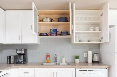 a kitchen with white cabinets and a sink at Comfy Liberty Village Home 1BD Steps from King St in Toronto