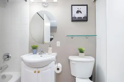 a bathroom with a sink and a toilet and a mirror at Comfy Liberty Village Home 1BD Steps from King St in Toronto