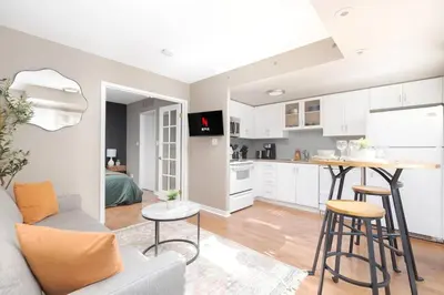 a living room with a couch and a kitchen at Comfy Liberty Village Home 1BD Steps from King St in Toronto