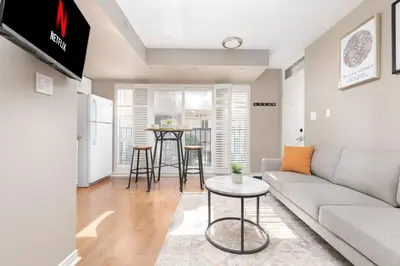 a living room with a couch and a table at Comfy Liberty Village Home 1BD Steps from King St in Toronto