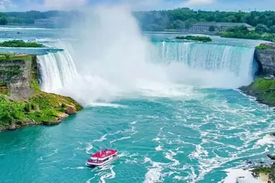 a boat in the water in front of a waterfall at 2 Bed Town ideal for a fun-filled family vacation in Niagara Falls