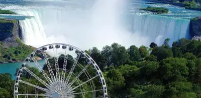 a ferris wheel in front of a waterfall at 2 Bed Town ideal for a fun-filled family vacation in Niagara Falls